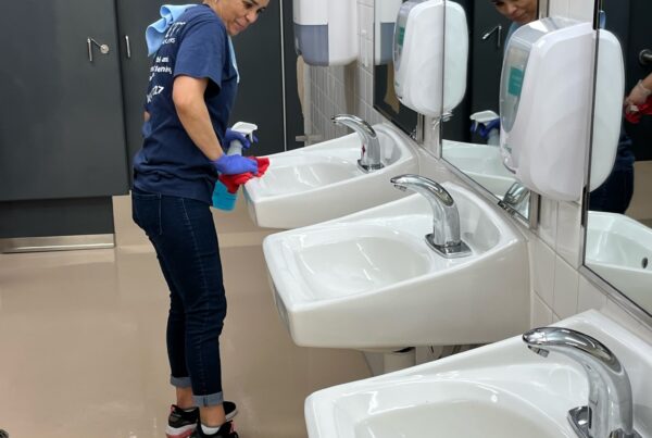 Commercial cleaning technician cleans sinks